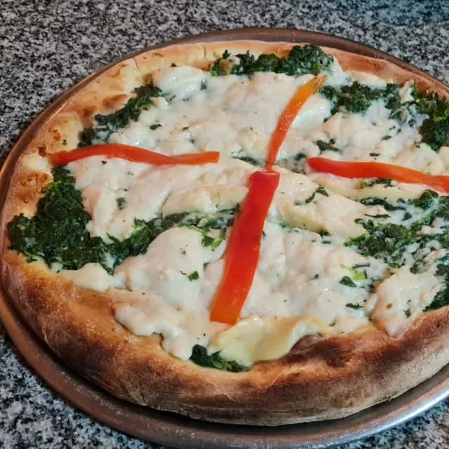 Pizza de espinaca con salsa blanca y morrón